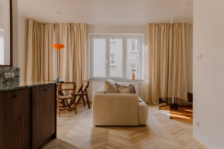 Wnętrze salonu w stylu quiet luxury, soft minimalizm i vintage z beżową sofą i drewnianymi akcentami.