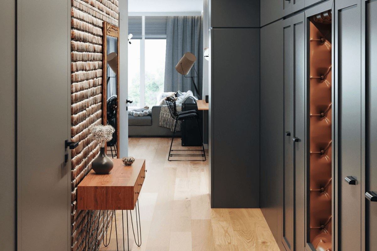 Przedpokój w stylu industrialnym i soft minimalizm z drewnianą podłogą i szafkami.
