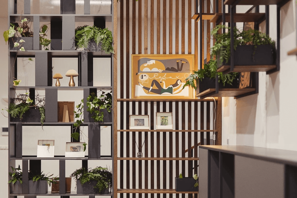 Wnętrze z eklektycznymi półkami, roślinami i drewnianymi akcentami. Styl dopamine decor, industrialny, rustykalny, vintage.