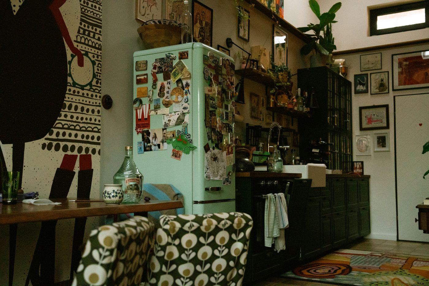 Kolorowa, eklektyczna kuchnia z miętową lodówką retro pełną magnesów