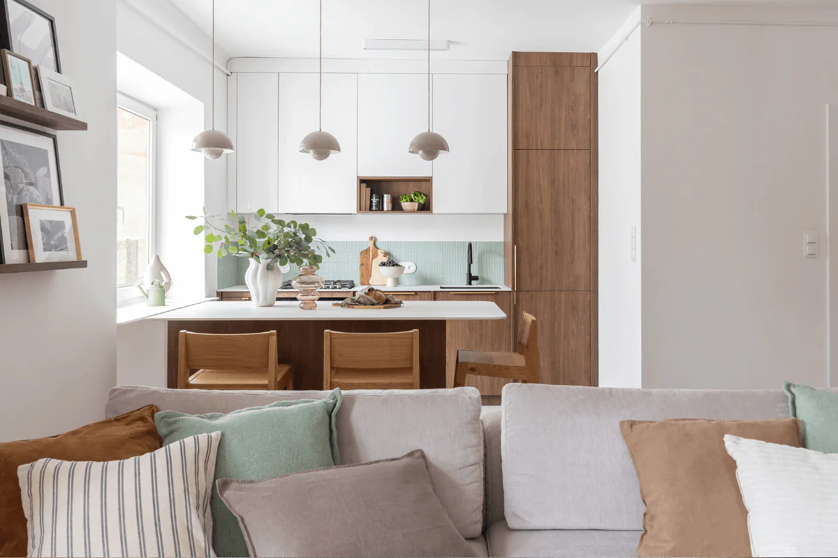 Kuchnia w stylu eklektycznym z drewnem, białymi meblami i roślinami.