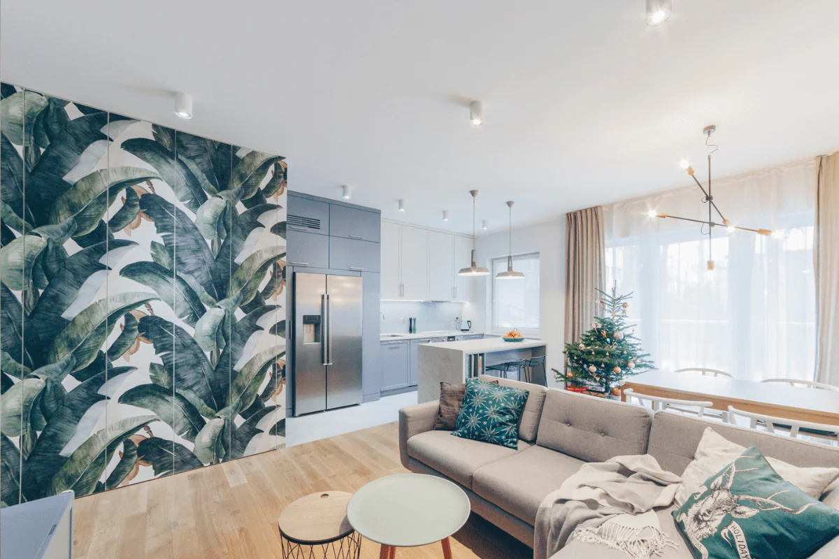 Wnętrze kuchni z nowoczesnym designem, zieloną ścianą i jasnymi meblami.