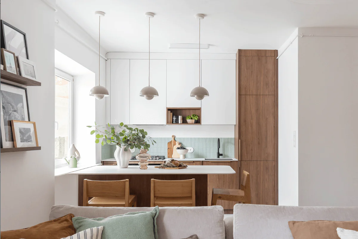 Kuchnia w stylu eklektycznym z drewnem, białymi meblami i roślinami.