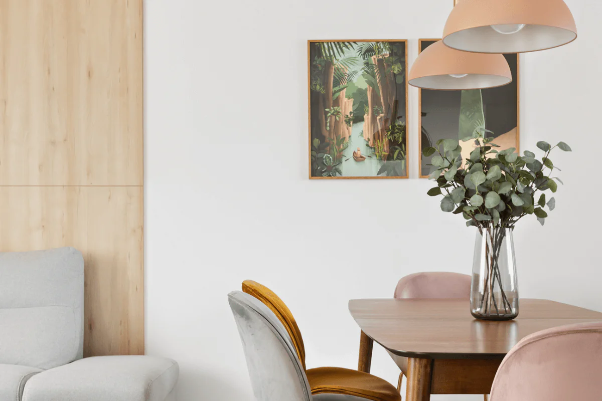 Wnętrze jadalni w stylu art deco, boho i glamour z drewnianym stołem i kolorowymi krzesłami.