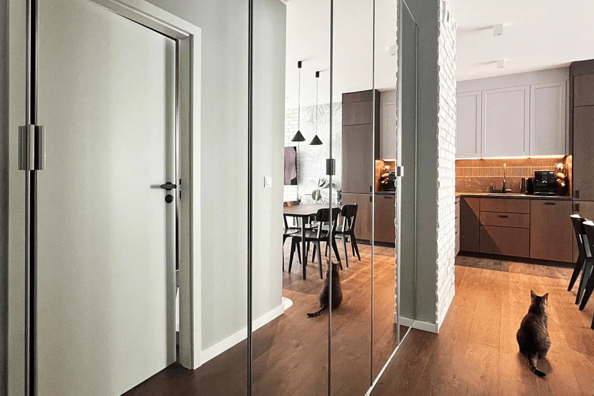 Wnętrze kuchni w stylu minimalistycznym z szarymi meblami i drewnianą podłogą.