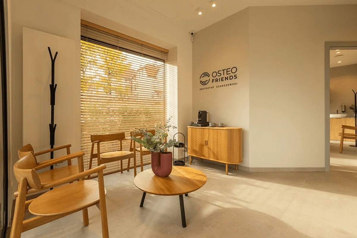 Poczekalnia z minimalistycznym wystrojem i drewnianymi meblami.