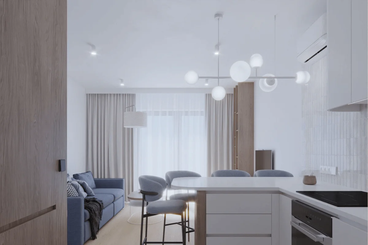 Wnętrze nowoczesnej kuchni z szarymi meblami i niebieską sofą.