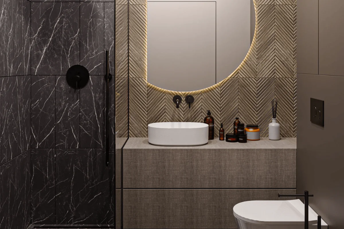 Wnętrze łazienki z czarnymi płytkami, minimalistyczną umywalką i lustrzanym akcentem.