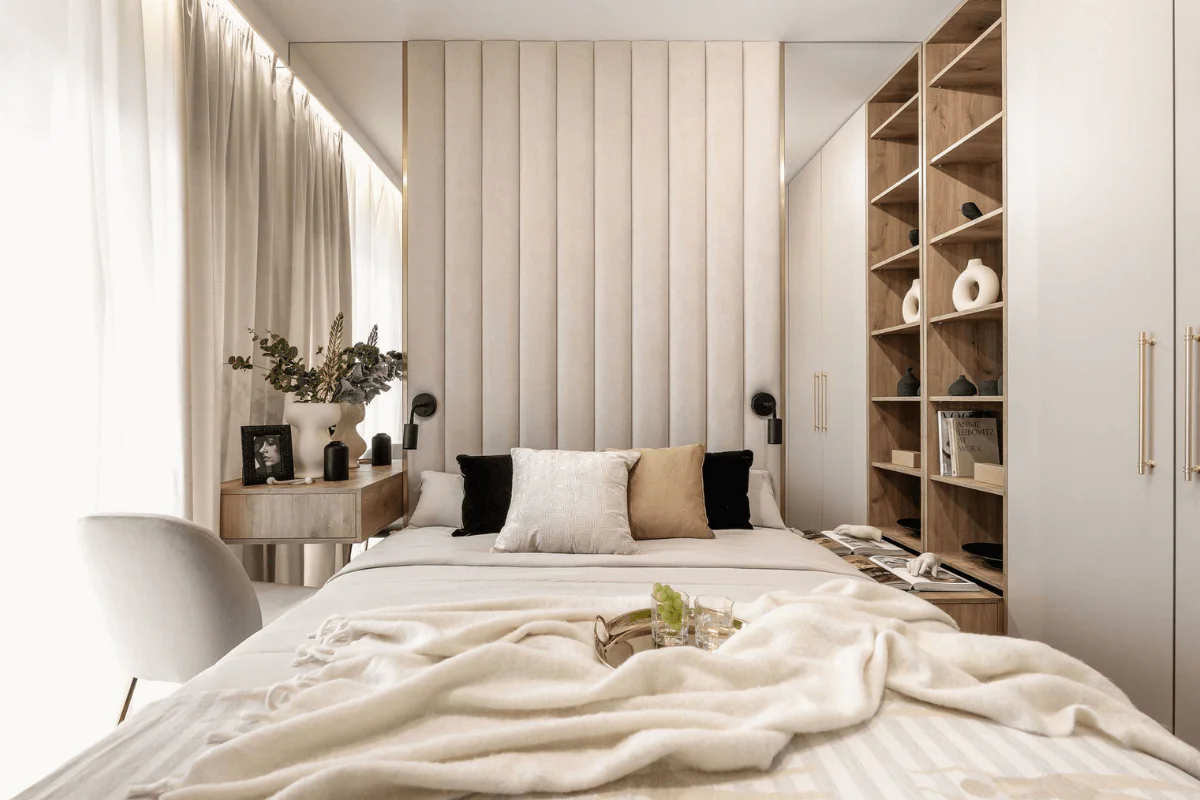 Sypialnia z beżowym łóżkiem, drewnianymi meblami i roślinami dekoracyjnymi.