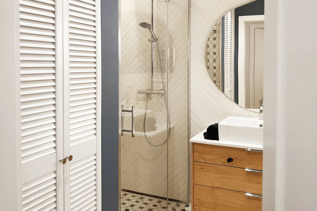 Wnętrze łazienki z prysznicem i drewnianymi elementami, styl tradycyjny i współczesny.