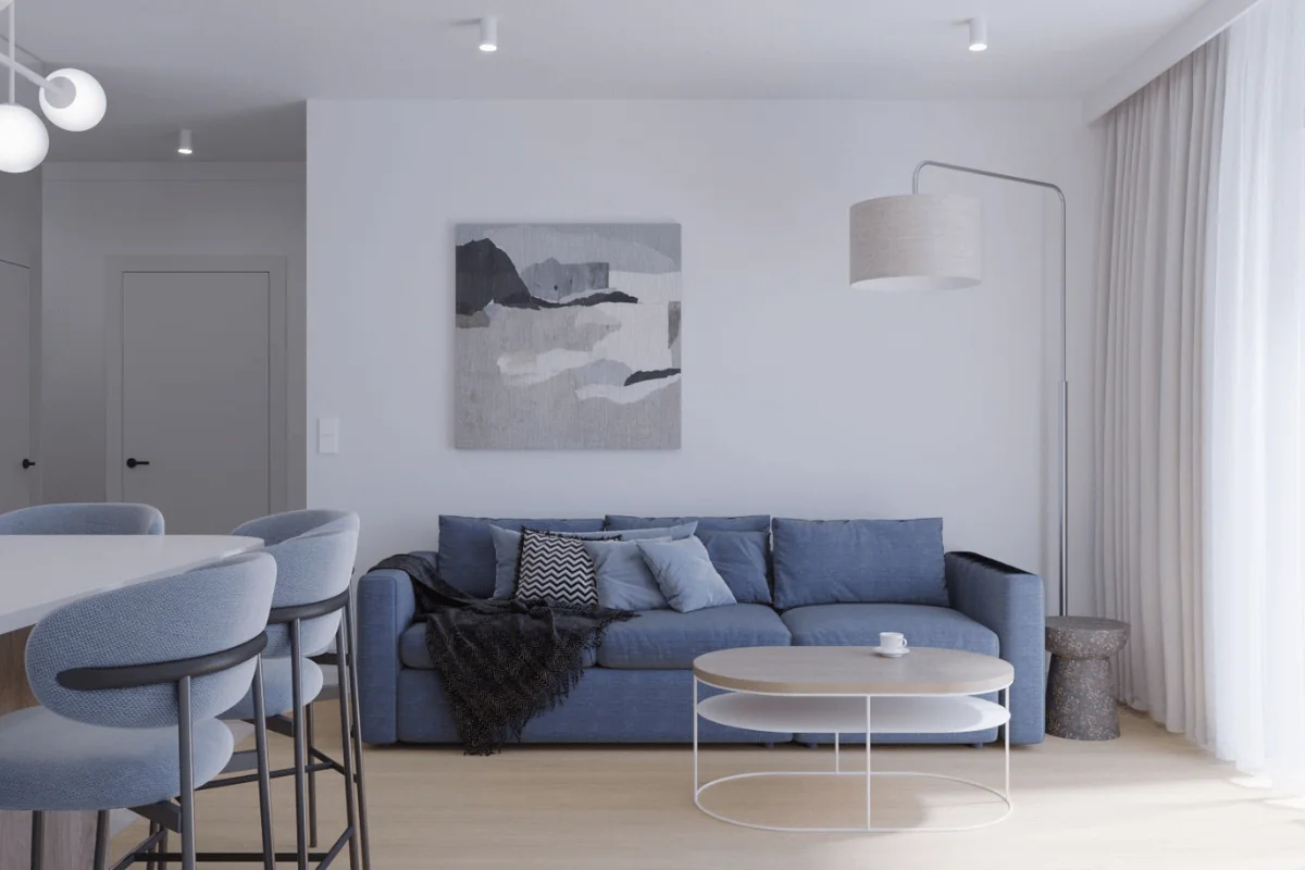 Nowoczesny salon z niebieską sofą, białym stolikiem i obrazem na ścianie.