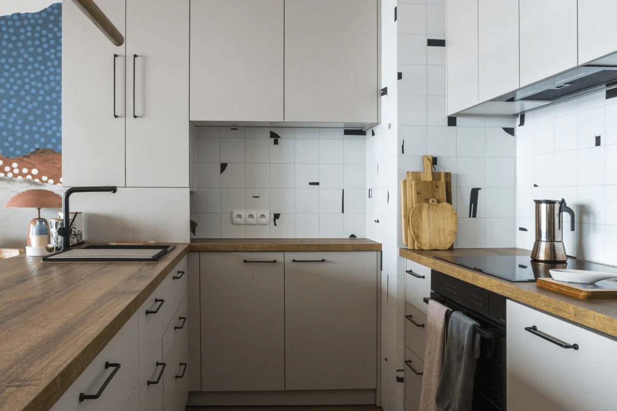 Kuchnia w stylu boho i współczesnym z białymi meblami i drewnianymi akcentami.