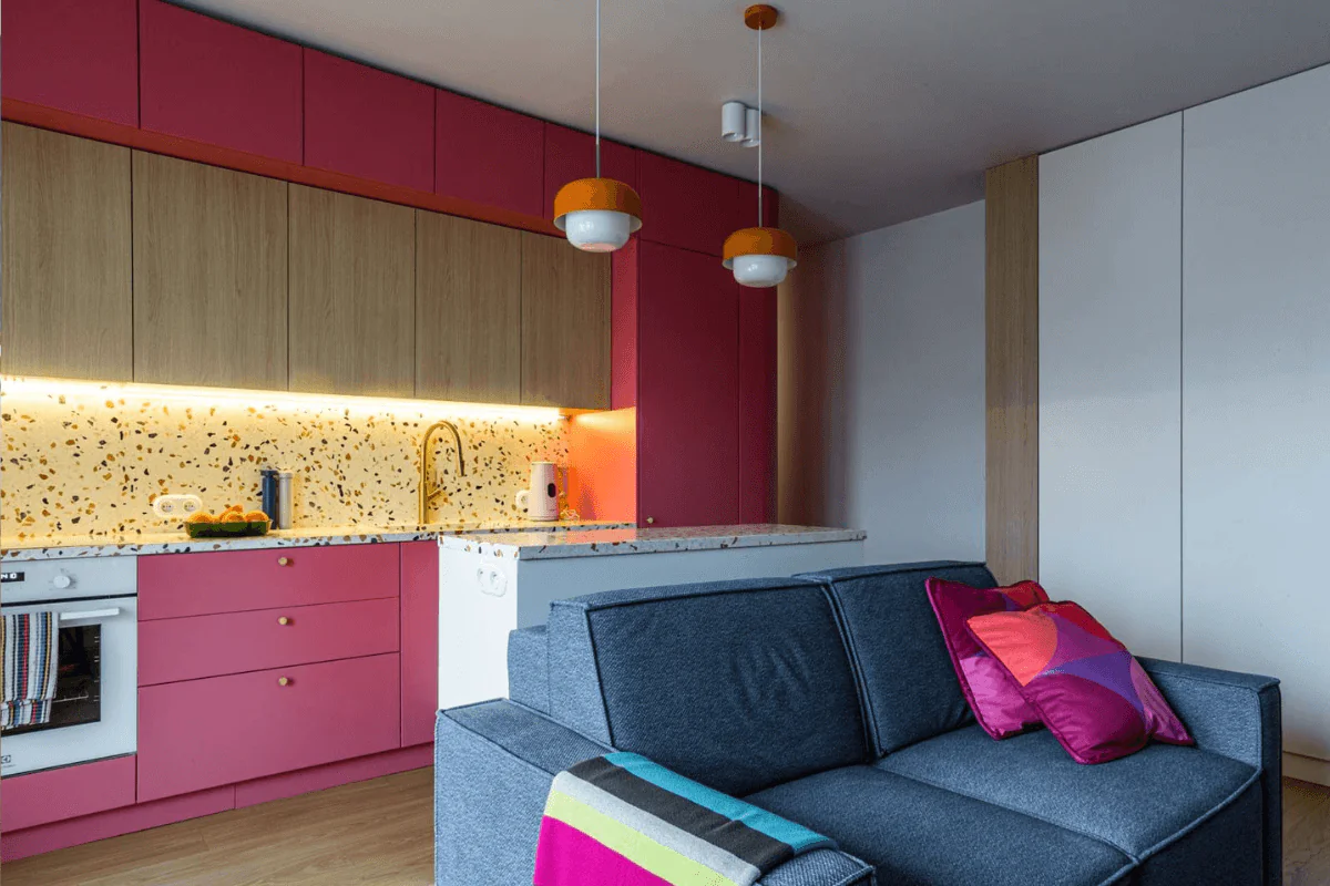 Wnętrze kuchni w stylu dopamine decor i vintage z różowymi meblami.