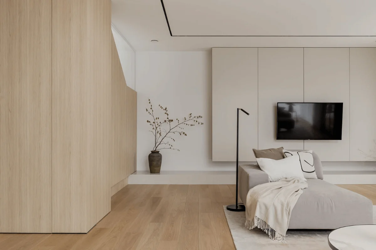 Wnętrze salonu w stylu japandi i minimalistycznym z drewnem i stonowanymi kolorami.