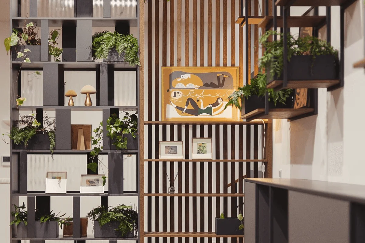 Wnętrze z eklektycznymi półkami, roślinami i drewnianymi akcentami. Styl dopamine decor, industrialny, rustykalny, vintage.