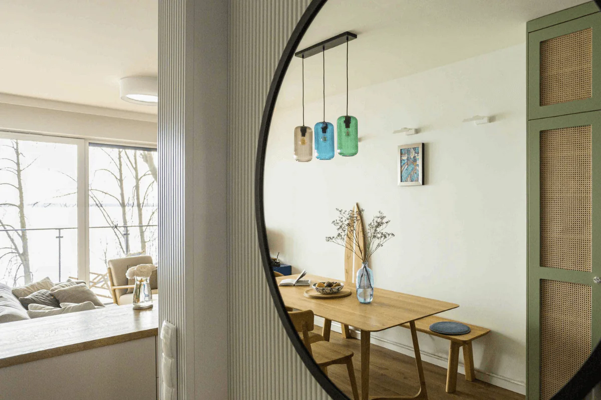 Jadalnia w stylu boho i współczesnym z drewnianym stołem i kolorowymi lampami