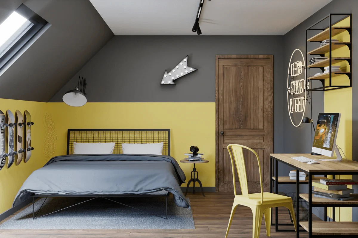 Wnętrze poddasza z szarymi ścianami, żółtymi akcentami i nowoczesnym biurkiem.