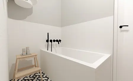 Wnętrze nowoczesnej łazienki z wanną i czarnymi detalami.