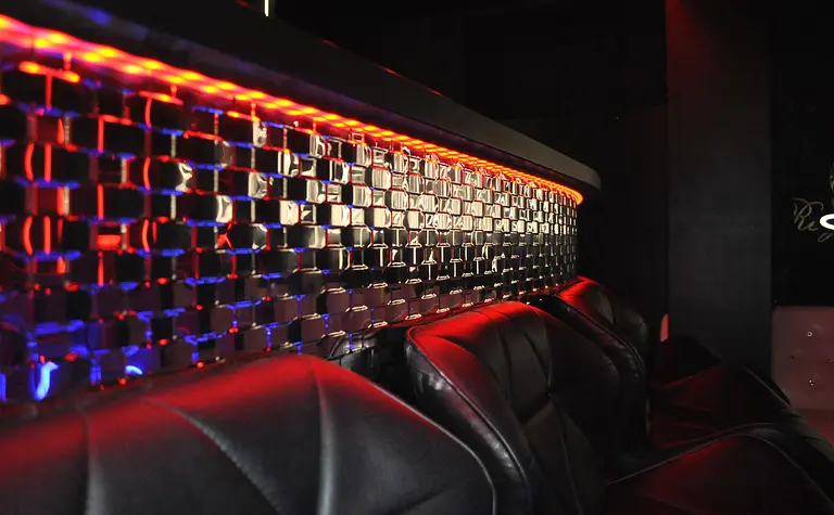 Wnętrze z czarnymi fotelami i świecącą ścianą w stylu glamour, nowoczesnym, współczesnym.