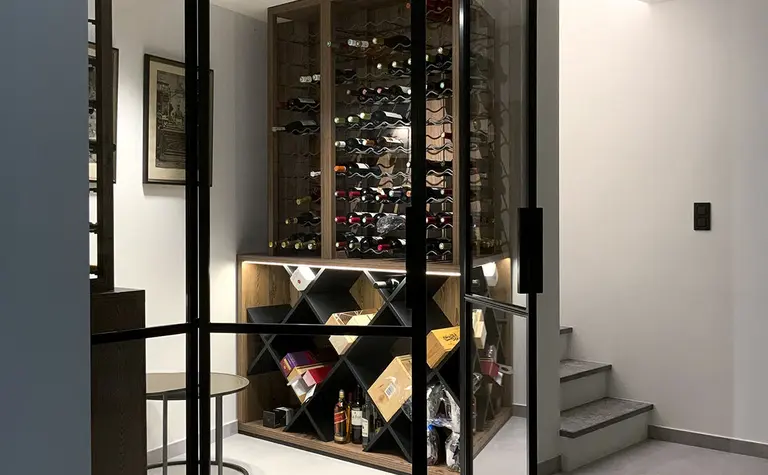 Przestrzeń z minimalistycznym regałem na wino i szklanymi drzwiami, styl minimaluxe i quiet luxury.