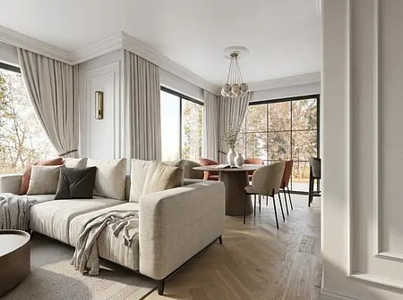 Wnętrze salonu z jasnym narożnikiem, okrągłym stołem i dużymi oknami, styl quiet luxury