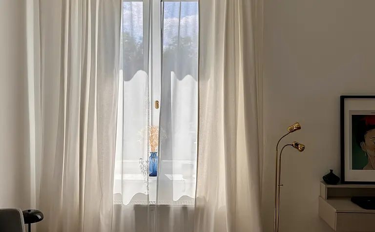 Sypialnia w stylu eklektycznym, skandynawskim i vintage z białymi zasłonami.