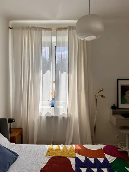 Sypialnia w stylu eklektycznym, skandynawskim i vintage z białymi zasłonami.