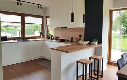 Kuchnia w stylu industrialnym i skandynawskim z białymi meblami i drewnianymi akcentami.