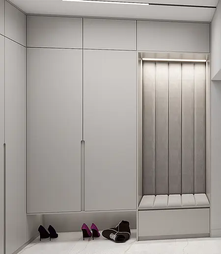 Minimalistyczna garderoba z szarymi szafkami i obszernym siedziskiem.