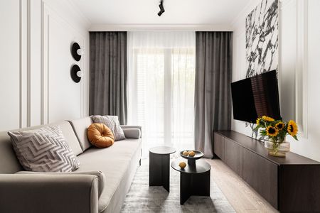 Wnętrze salonu z szarymi zasłonami, sofą i dekoracjami