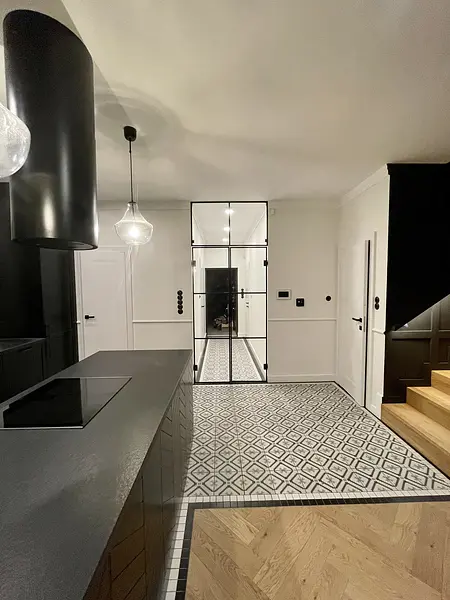 Wnętrze kuchni w stylu art deco z czarnymi meblami, industrialnymi akcentami i rustykalnymi detalami.