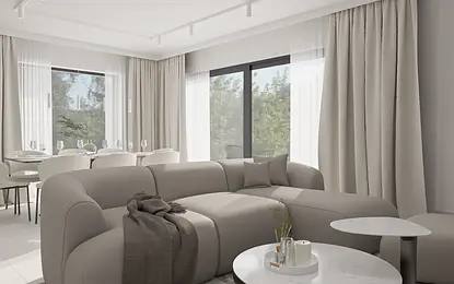 Wnętrze minimalistycznego salonu z szarym narożnikiem i białymi zasłonami.