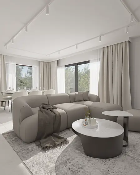 Wnętrze minimalistycznego salonu z szarym narożnikiem i białymi zasłonami.