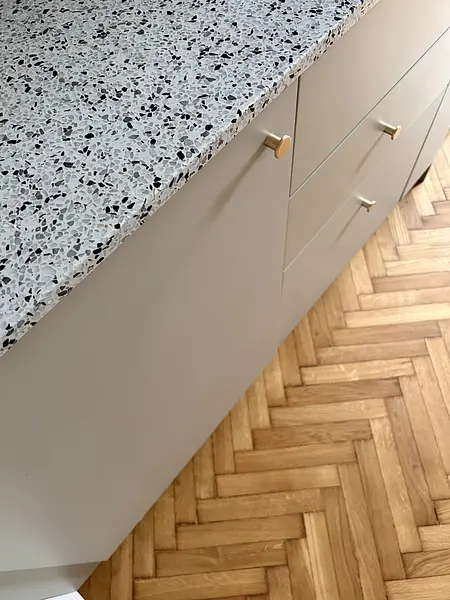 Wnętrze kuchni z szarym blatem, drewnianą podłogą w stylu eklektycznym, skandynawskim i vintage.