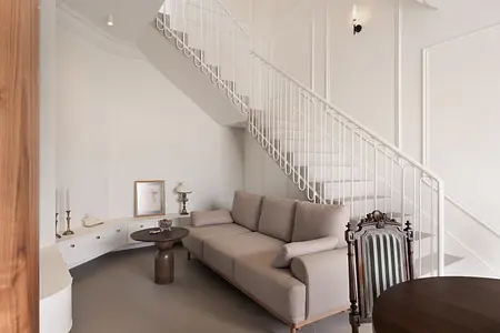 Wnętrze salonu w stylu eklektycznym z beżową sofą i vintage akcentami.