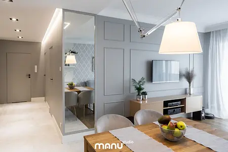 Wnętrze jadalni w stylu art deco, nowoczesnym i tradycyjnym z szarymi ścianami i drewnianym stołem.