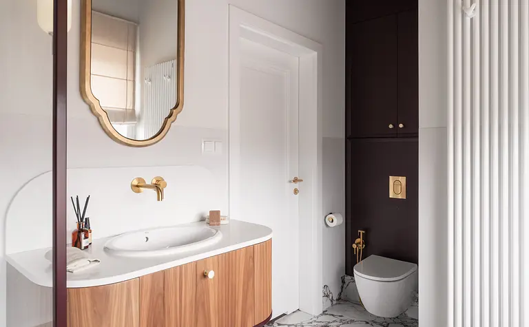 Wnętrze łazienki z eklektycznymi i vintage akcentami, drewniana szafka, marmurowa posadzka.