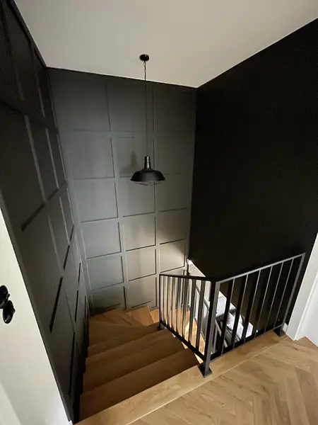 Schody w stylu rustykalnym z czarną balustradą i drewnianymi detalami.