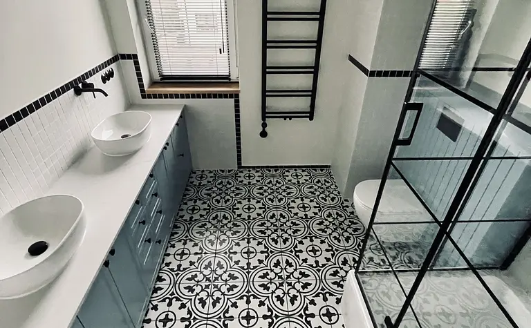 Wnętrze łazienki z niebieskimi meblami, wzorzystą podłogą, styl art deco, industrialny, vintage.