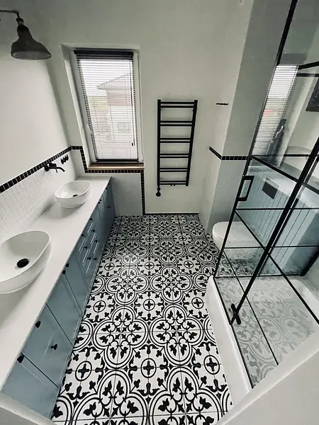 Wnętrze łazienki z niebieskimi meblami, wzorzystą podłogą, styl art deco, industrialny, vintage.