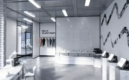 Wnętrze biura z minimalistycznym designem, białymi meblami i nowoczesnym oświetleniem.