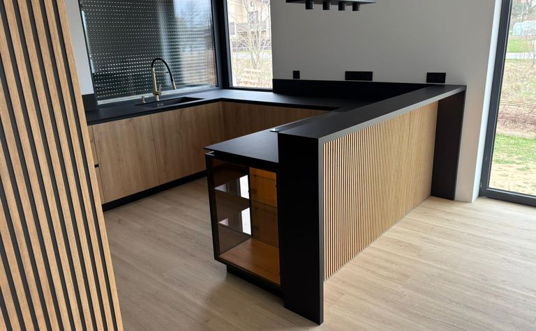 Nowoczesna kuchnia w stylu quiet luxury z drewnem i czarnymi detalami.