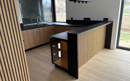 Nowoczesna kuchnia w stylu quiet luxury z drewnem i czarnymi detalami.