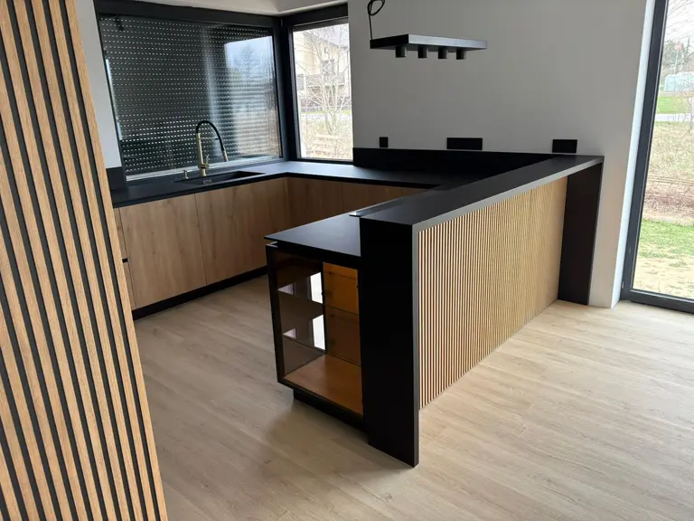Nowoczesna kuchnia w stylu quiet luxury z drewnem i czarnymi detalami.