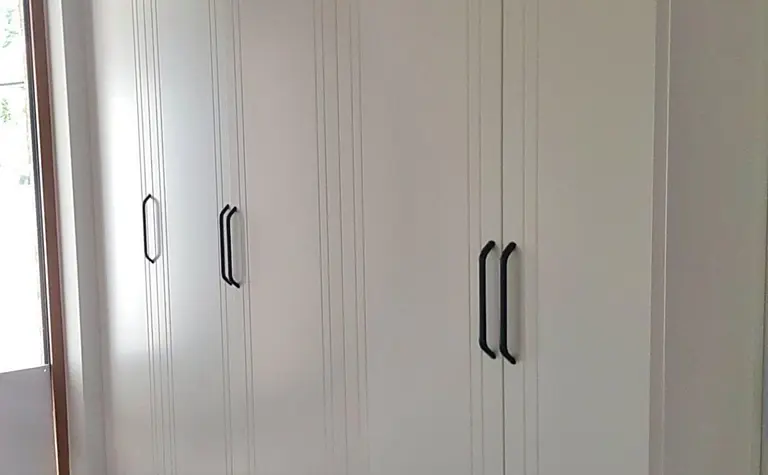 Garderoba z białymi meblami, industrialnym i skandynawskim stylem.