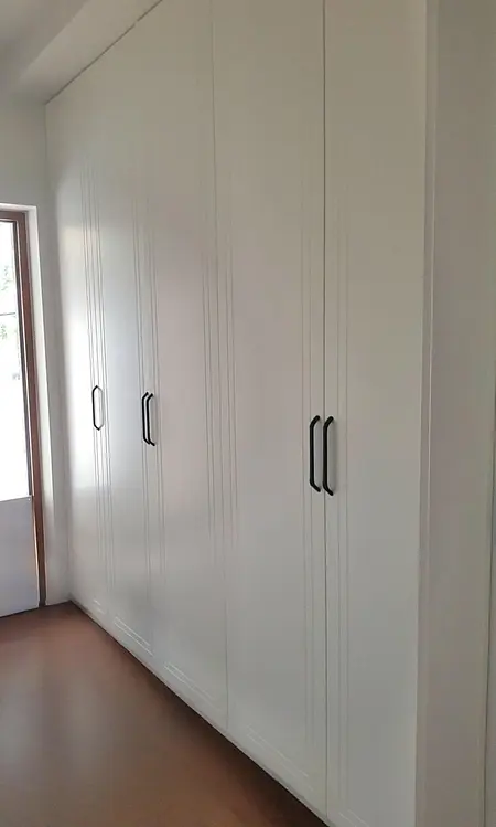 Garderoba z białymi meblami, industrialnym i skandynawskim stylem.