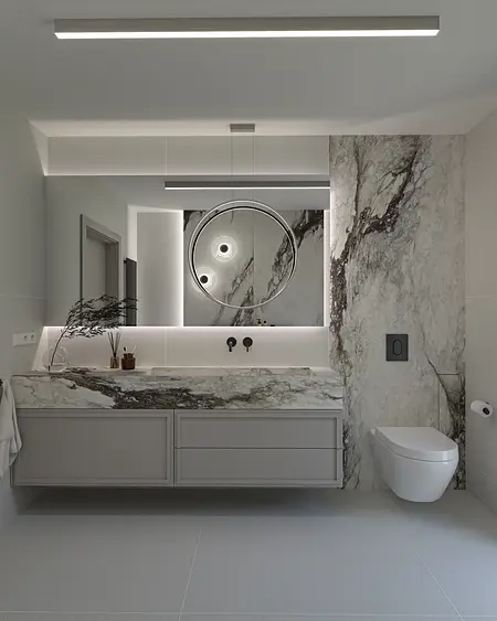Nowoczesna łazienka z marmurową umywalką, minimalistycznym oświetleniem i współczesnymi akcentami.
