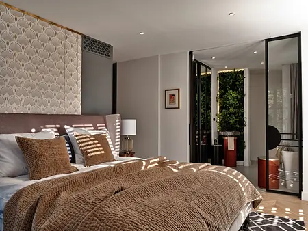 Wnętrze sypialni w stylu art deco z roślinnym akcentem i nowoczesnymi meblami.