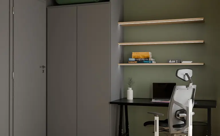 Gabinet w stylu soft minimalizmu z zieloną ścianą i szarym biurkiem.