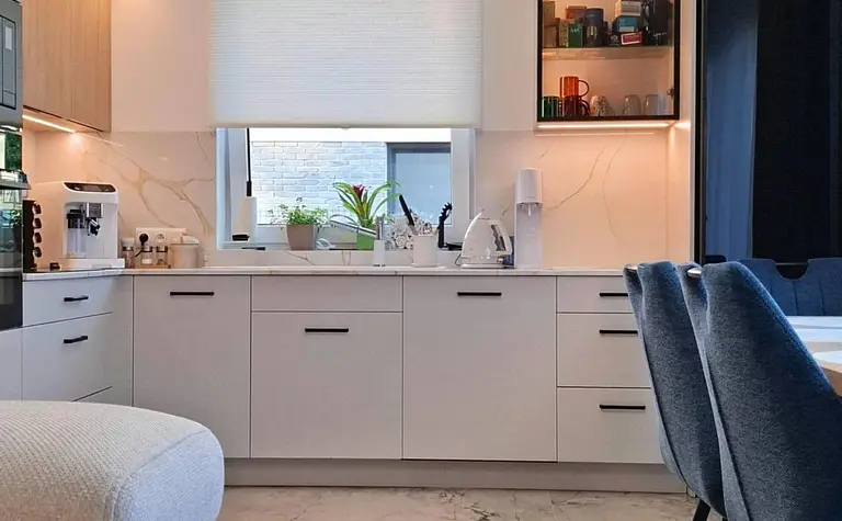 Wnętrze nowoczesnej kuchni skandynawskiej z białymi meblami i drewnianymi akcentami.